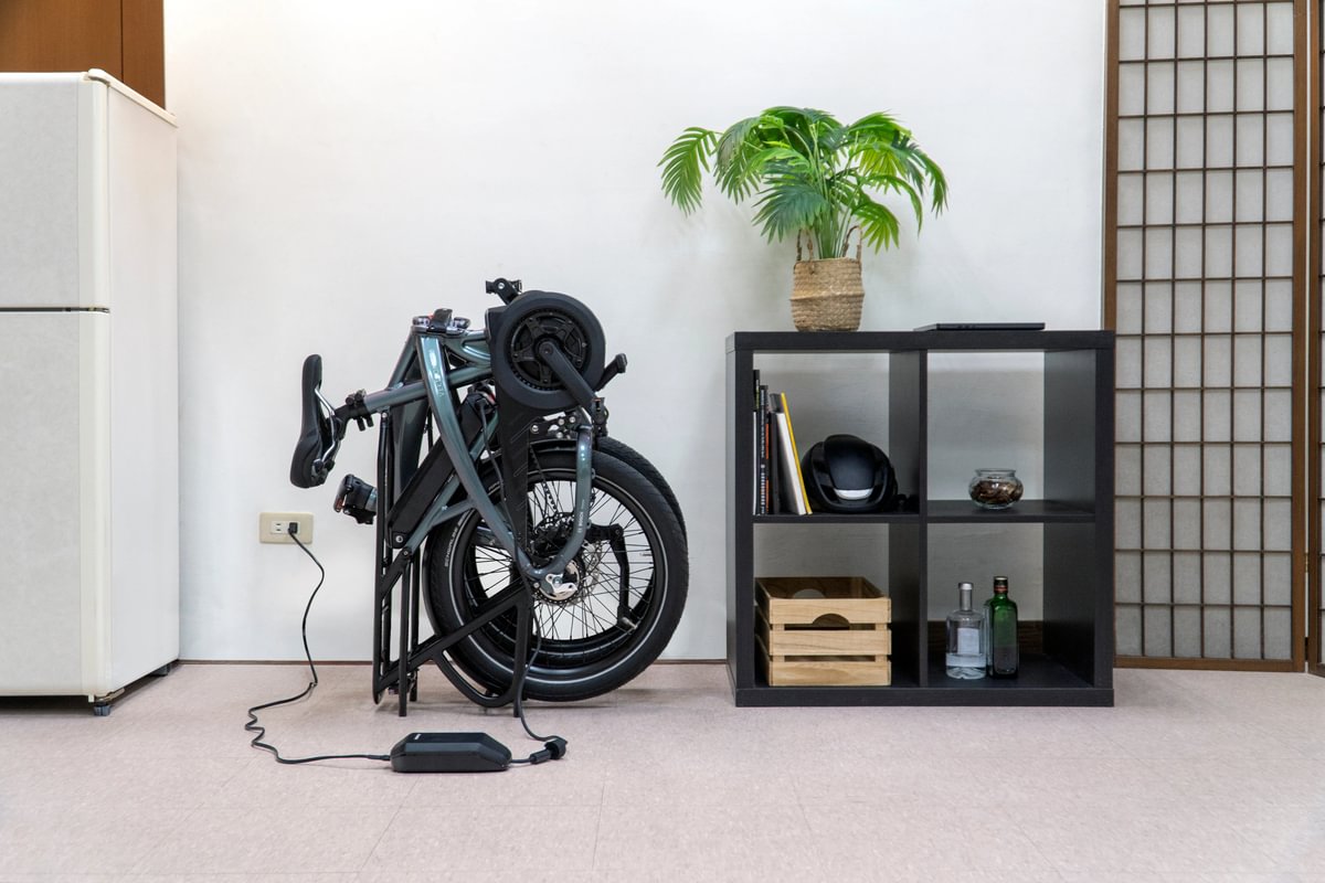 image of Vektron folding e-bike shown plugged in for charging inside home