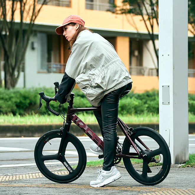 A woman is riding Surge bike along a city street.