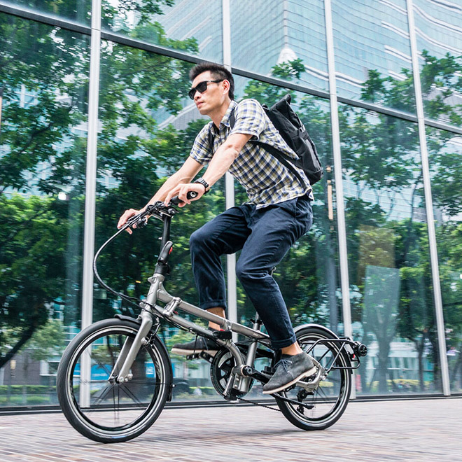 A man is riding BYB folding bike on the street.