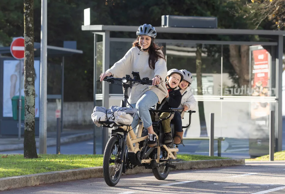 A mother rides the GSD Gen 3 and carries her two kids in the child seats at the back