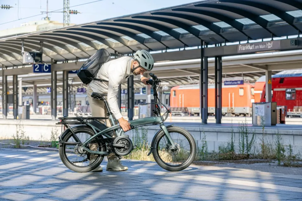 Commuter on a train platform folding the Tern Vektron Gen 4 folding ebike