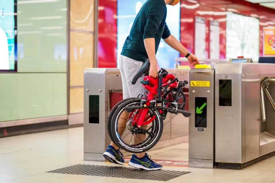 Man bringing a folded Tern BYB P10 folding bike into a metro station