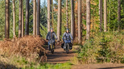 A family of three riding 2 Tern Orox adventure e-cargo bikes