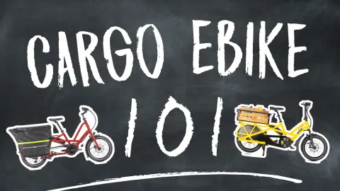 Cargo E-Bike 101 written in chalk on a chalkboard with cargo ebike stickers