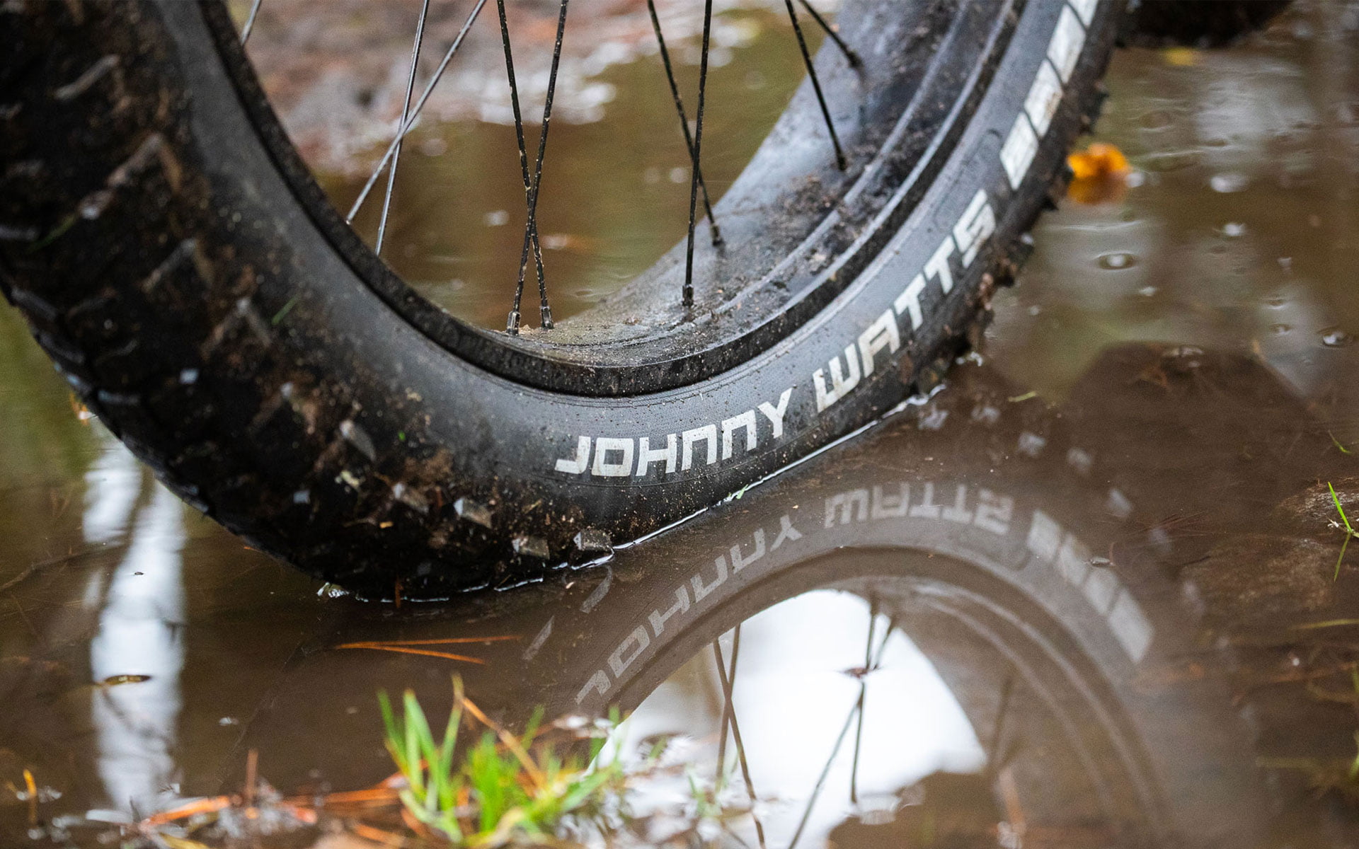 The tire on the waterlogged muddy ground.